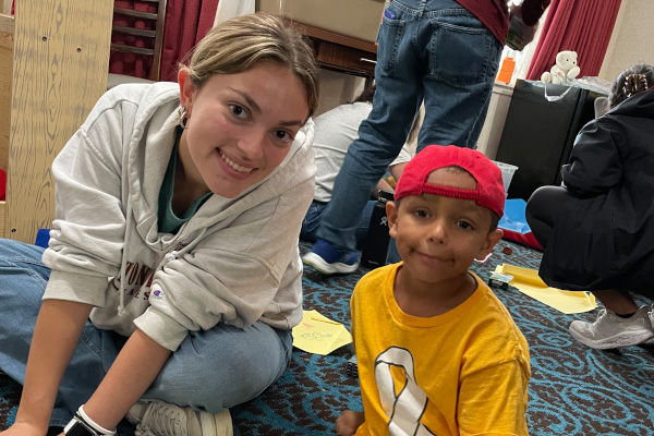 Student with a little boy at Catholic Charities shelter