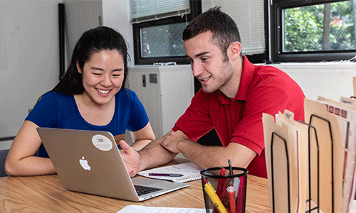 Two students reviewing resume on a computer