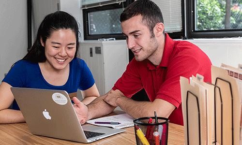 peer career coach and student reviewing resume on computer