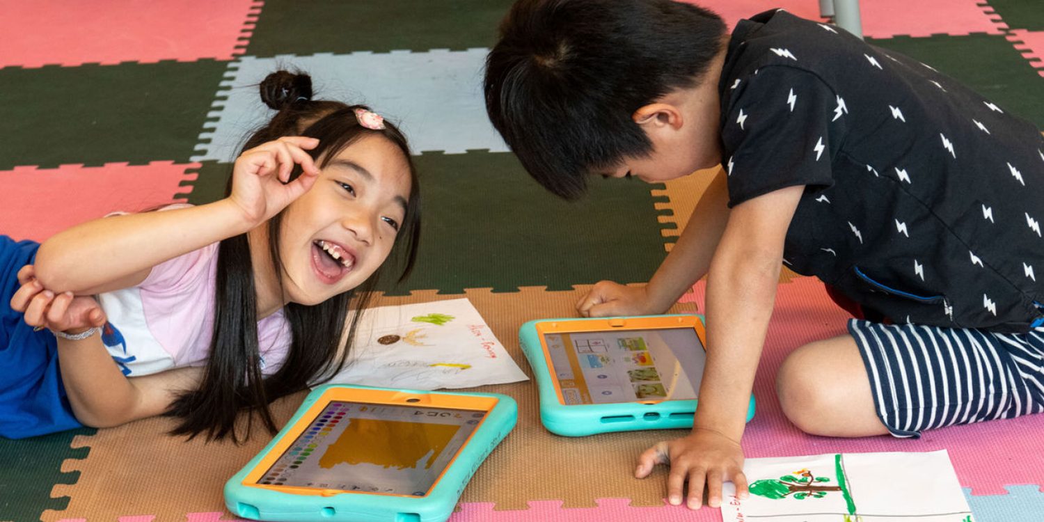 Two students working with ScratchJr on iPads at DevTech Research Group’s summer camp