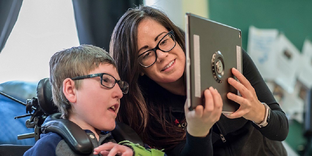 Photo of Campus School student with teacher looking at an iPad