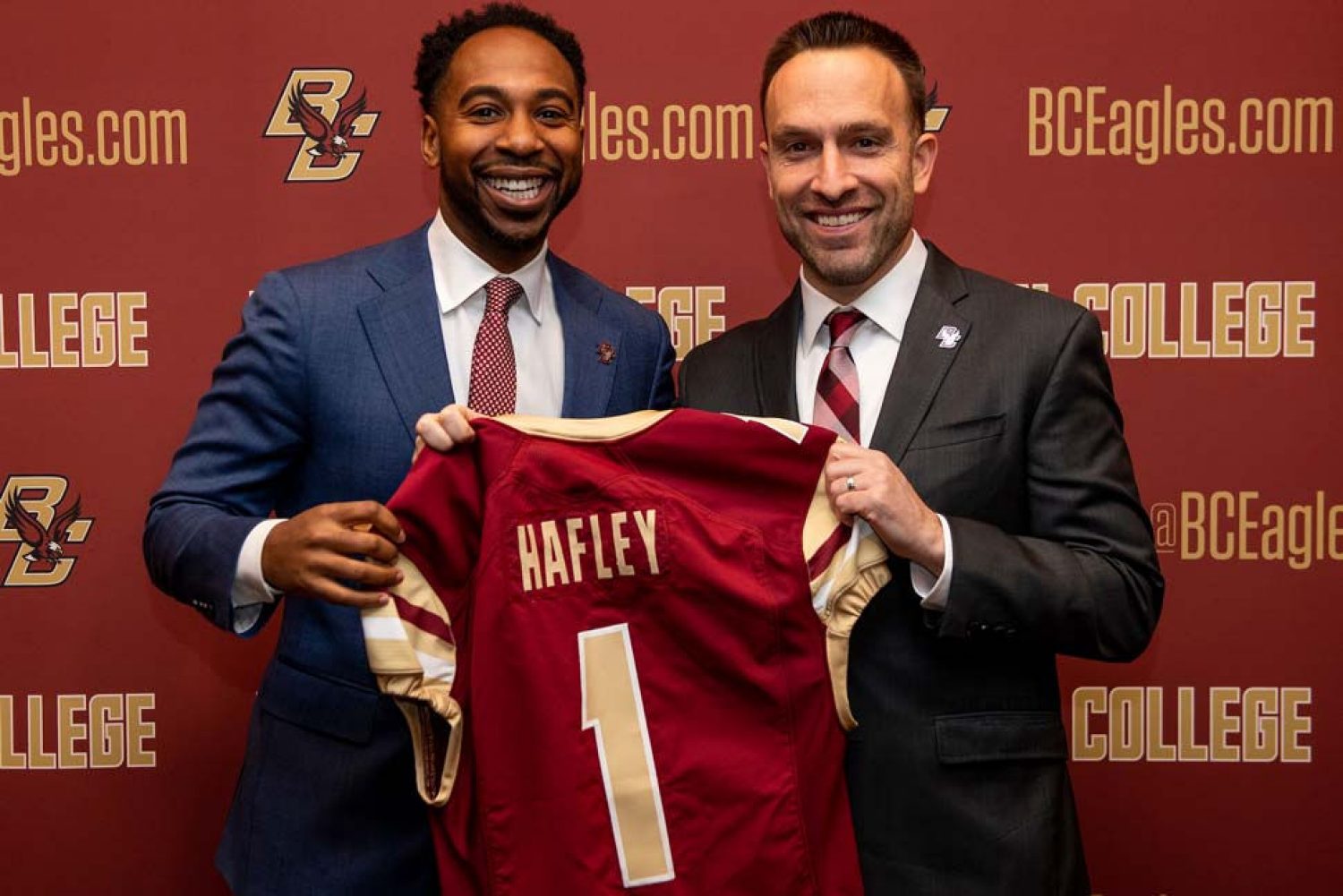 Martin Jarmond and Jeff Hafley both holding a football jersey with Hafley's name the back.