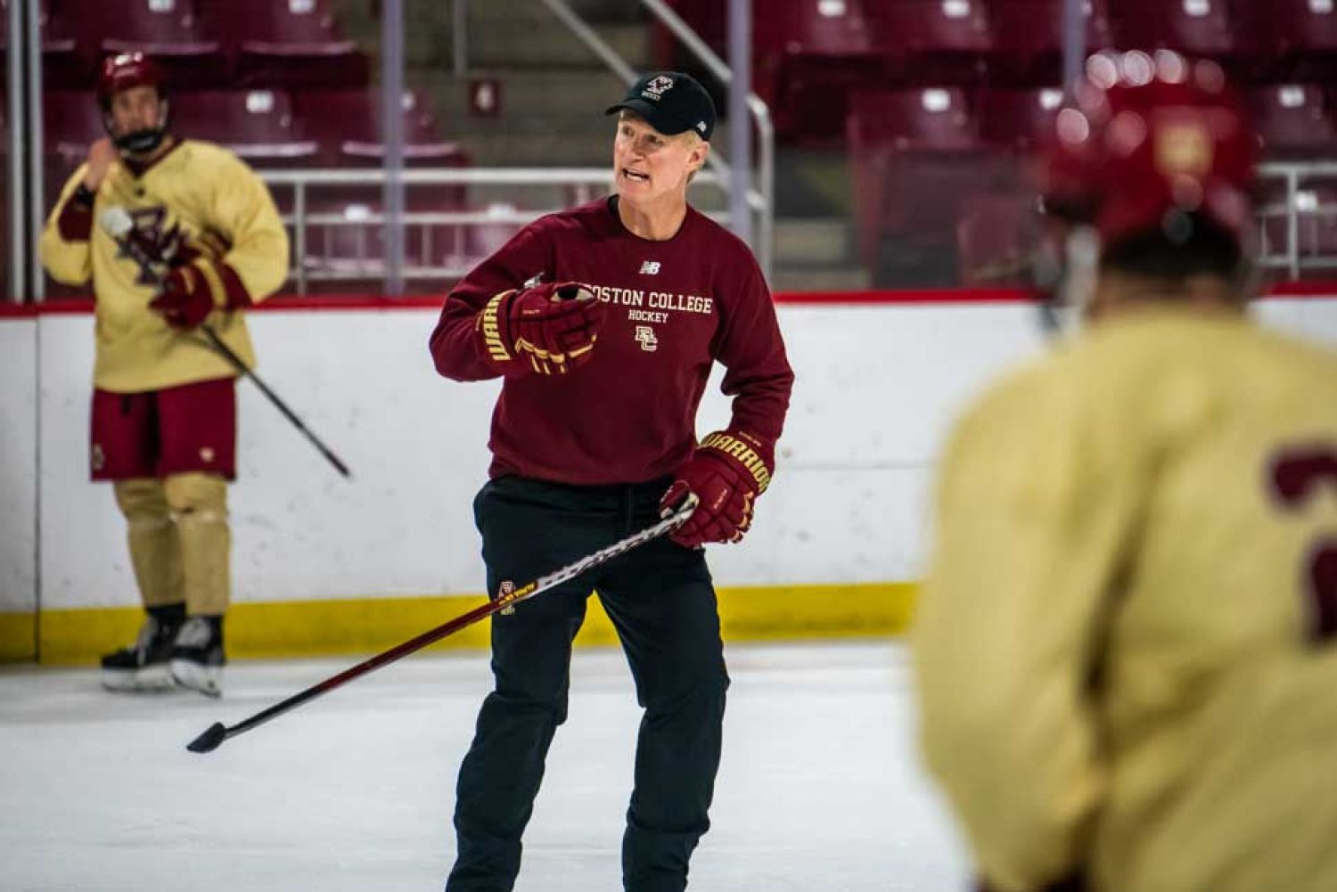 Coach Greg Brown coaching on ice with players.