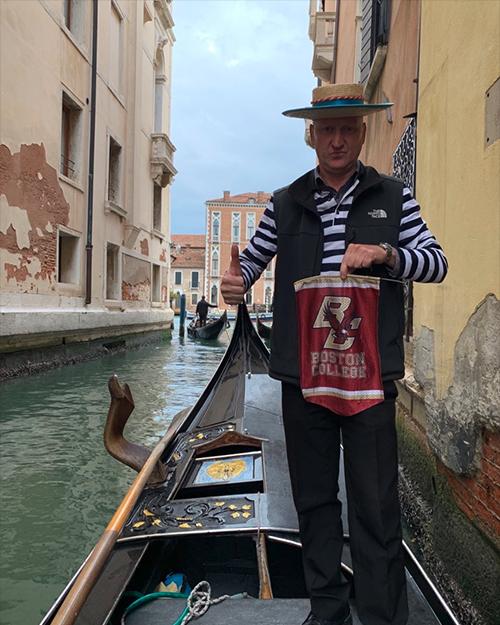A gondolier in Venice holding a BC banner