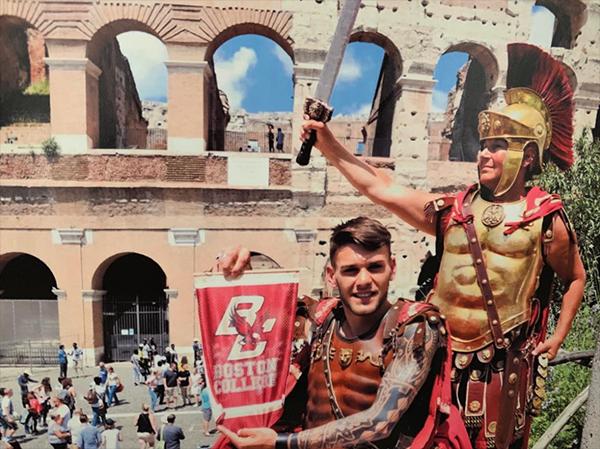Roman soldiers holding a BC banner at the Colosseum