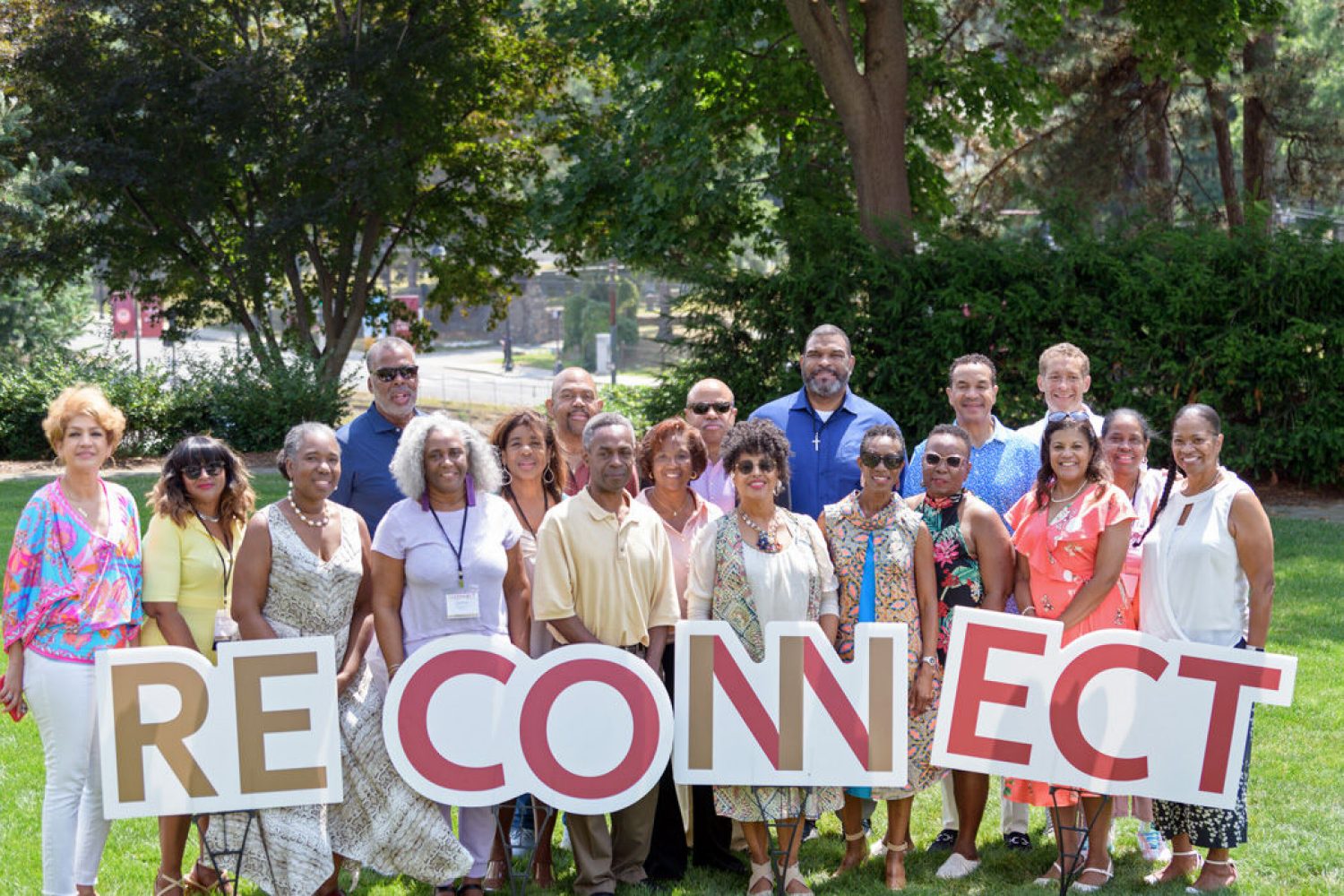 a group of attendees holding up big letters spelling RECONNECT