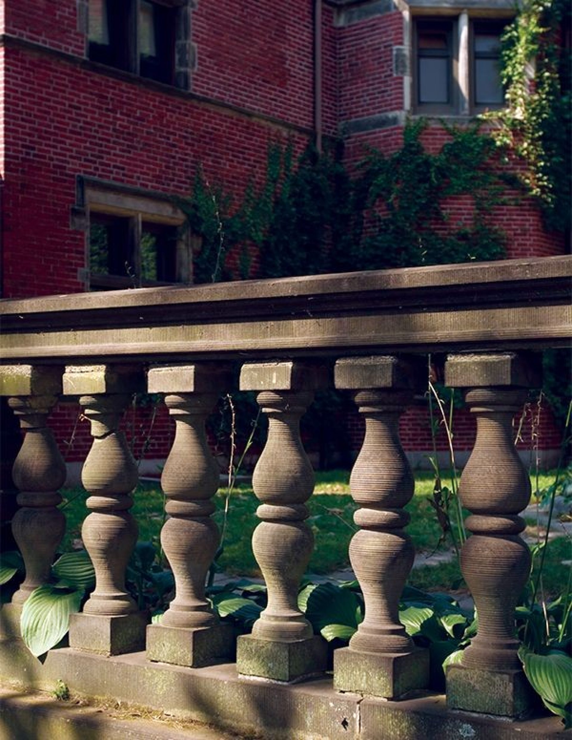 A stone fence in front of a brick building
