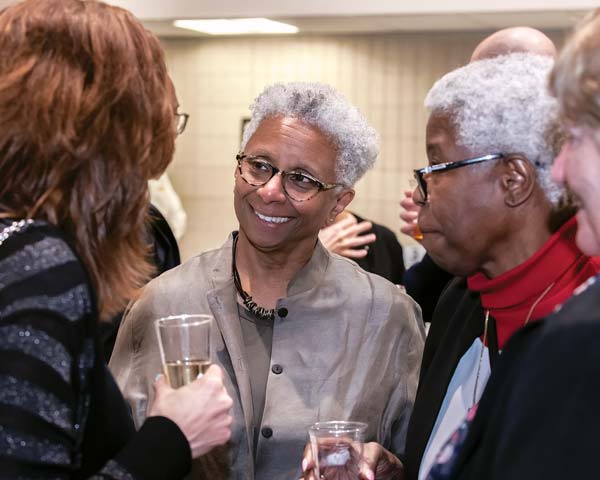M. Shawn Copeland speaking with people at a reception