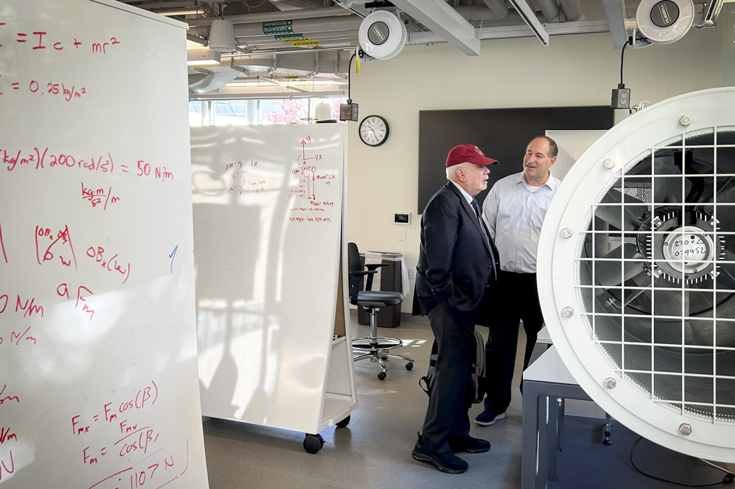 John Kozarich and Glenn Gaudette discussing a piece of lab equipment