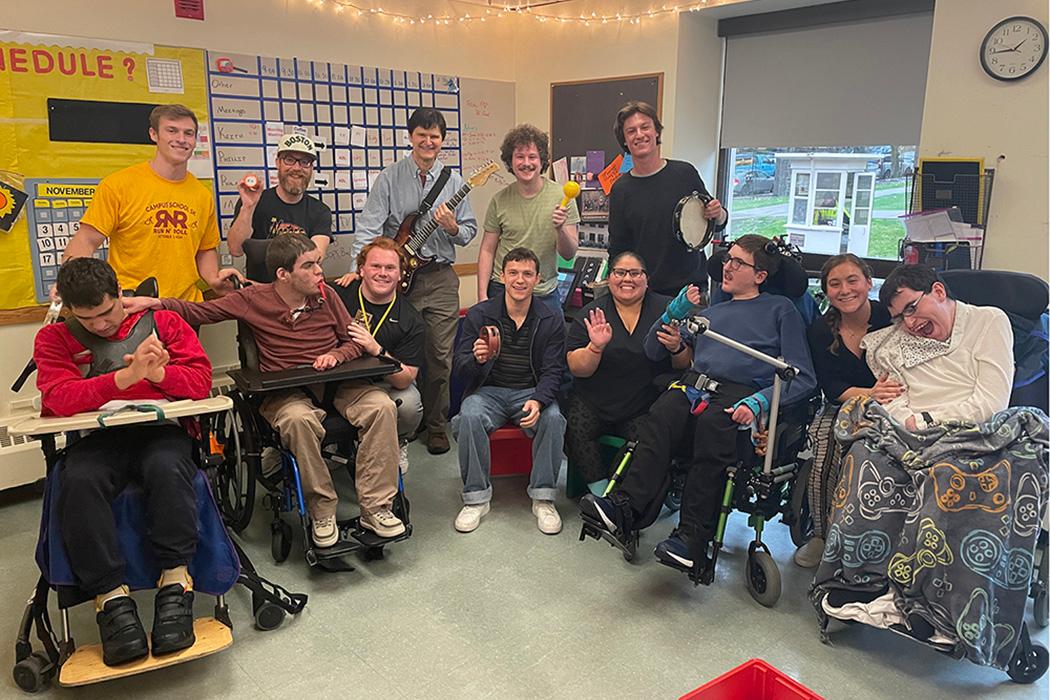 A classroom of teachers and students, some holding musical instruments